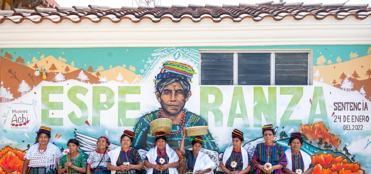 Créditos: Mujeres Achi frente al mural elaborado como parte de las medidas de reparación en el juicio de 2023. Foto Impunity Watch Guatemala