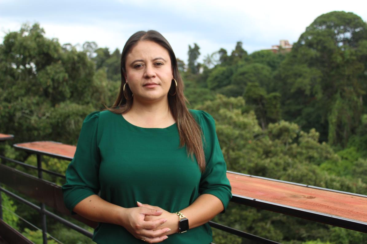 La exfiscal de la Fiscalía Especial contra la Impunidad (FECI), Paola Pimentel viste una camisa de manga larga verde mientras se encuentra al aire libre, rodeada por un paisaje de montañas.